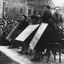 Antisemitische Maßnahmen: Drei jüdische Frauen in Linz werden am Pranger der gaffenden Menge zur Schau gestellt; man schneidet ihnen die Haare ab, nachdem man ihnen ein Schild umgehängt hat, auf dem steht: "Ich bin aus der Volksgemeinschaft ausgestoßen", November 1938. Fotograph: BPK